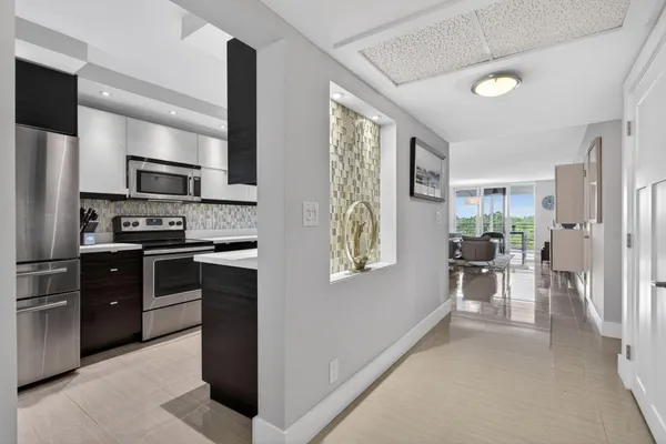 a kitchen with stainless steel appliances kitchen island granite countertop a refrigerator and a stove top oven