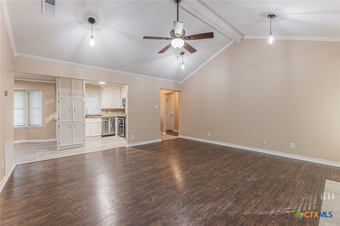 1102 End O Trail Harker Heights, TX 76548 - Photo 7 of 38 an empty room with wooden floor ceiling fan and kitchen view