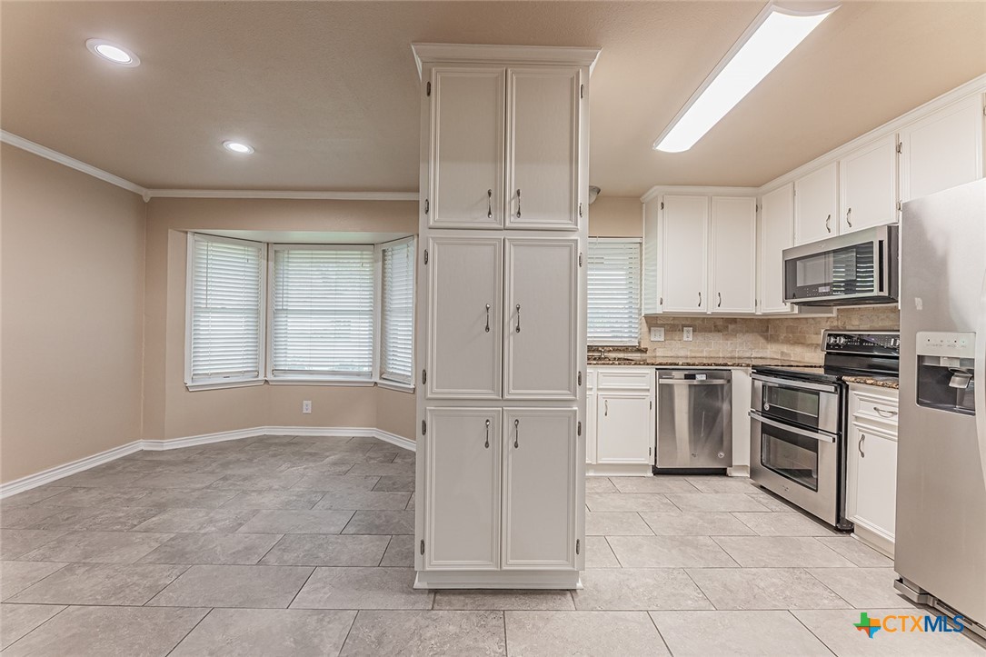 1102 End O Trail Harker Heights, TX 76548 - Photo 8 of 38 a kitchen with white cabinets and stainless steel appliances