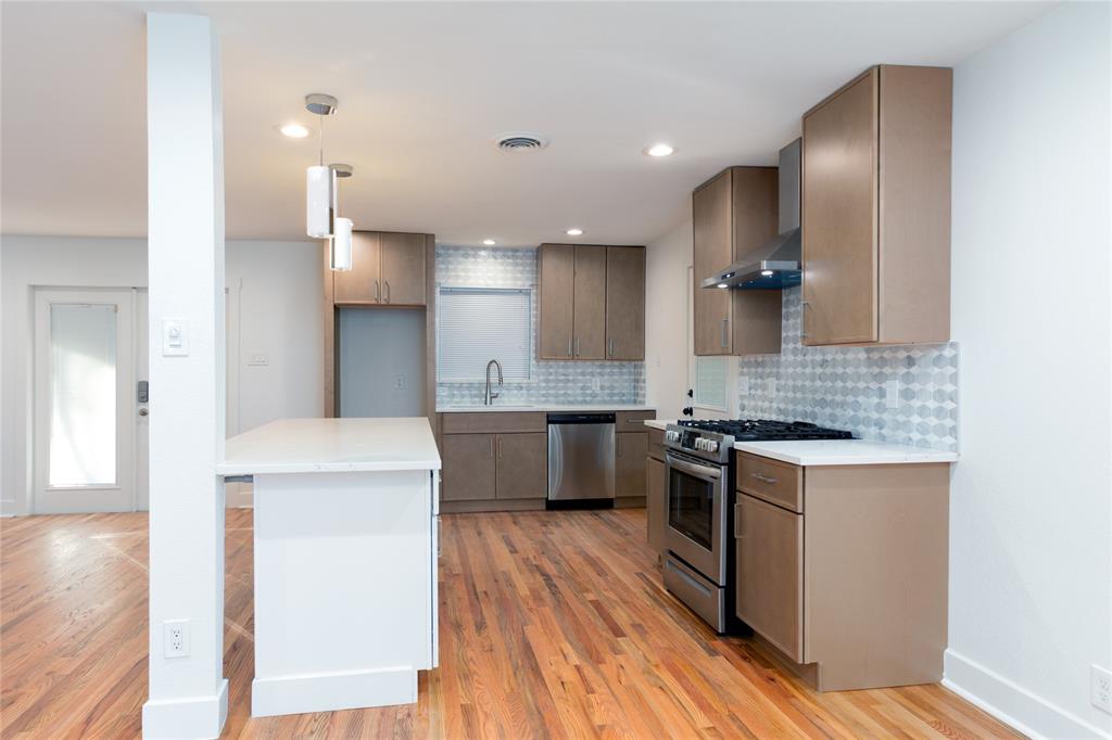 1241 Stevens Ridge Drive Dallas, TX 75211 - Photo 6 of 18 a large kitchen with a center island wooden floor and stainless steel appliances