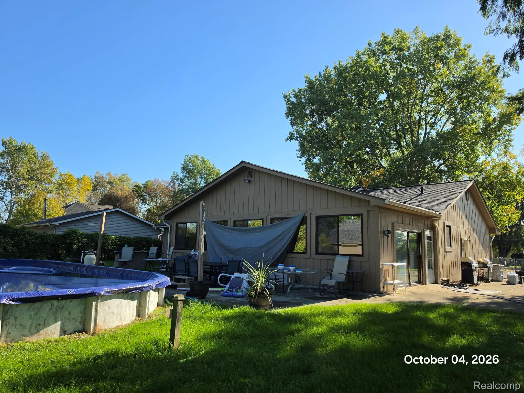 34781 Union Lake Road Clinton Township, MI 48035 - Photo 27 of 38 Above-ground pool, expansive concrete patio, large windows, sliding glass door, mature landscaping