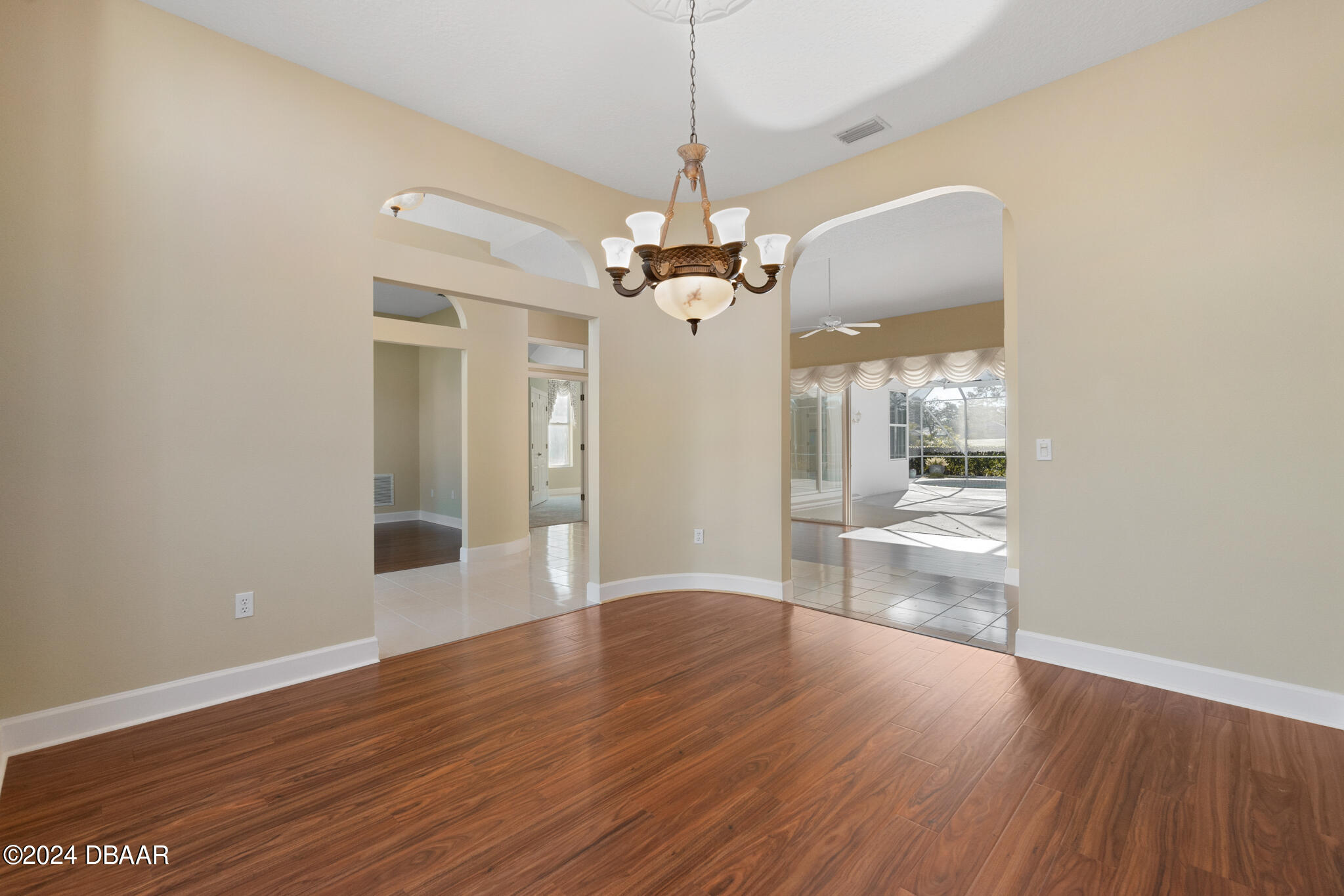710 Dolphin Head Lane Ormond Beach, FL 32174 - Photo 6 of 42 a view of a big room with wooden floor a kitchen and chandelier