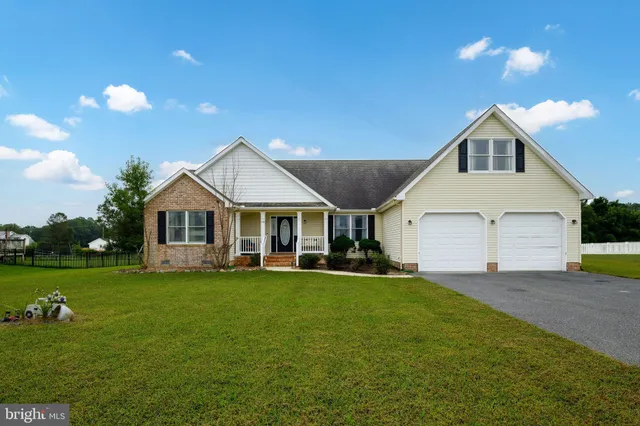 a front view of a house with a garden and yard