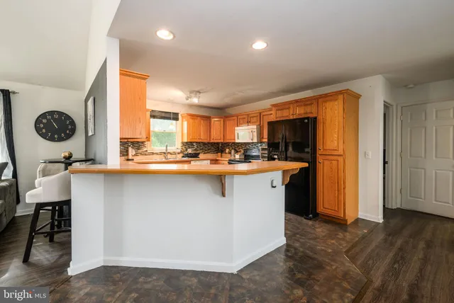 a kitchen with stainless steel appliances granite countertop sink stove refrigerator and cabinets