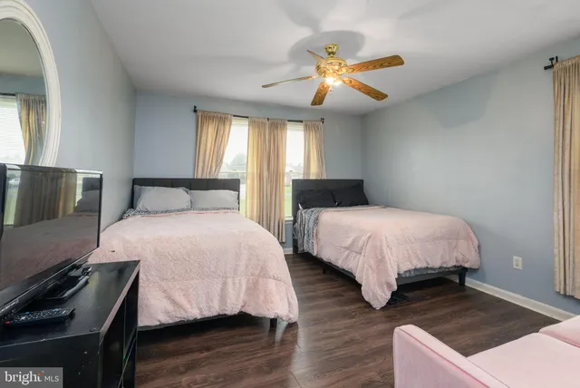 a view of a room with wooden floor and ceiling fan