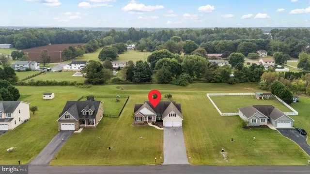 an aerial view of residential houses with outdoor space and parking
