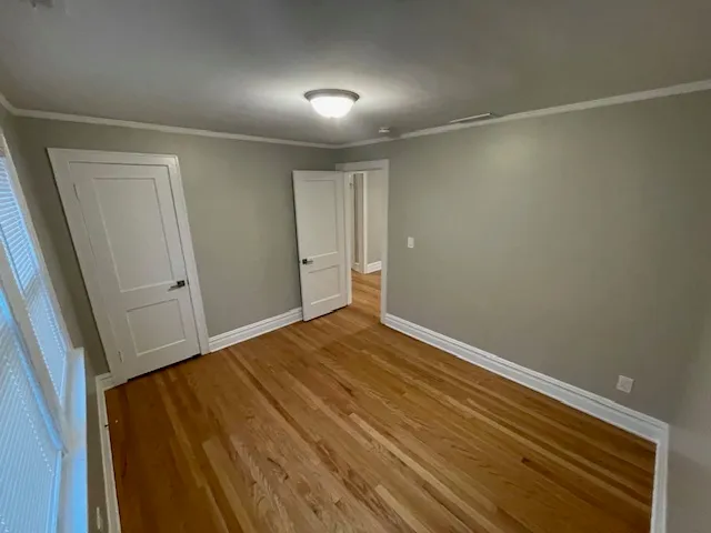 an empty room with wooden floor and closet