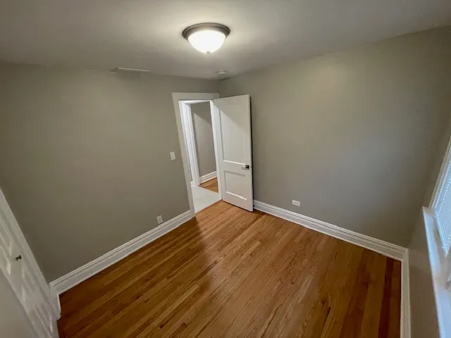 an empty room with wooden floor and closet