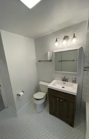 a bathroom with a toilet a sink and mirror
