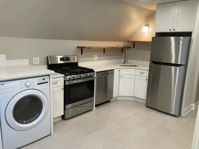 a kitchen with a stove top oven and refrigerator
