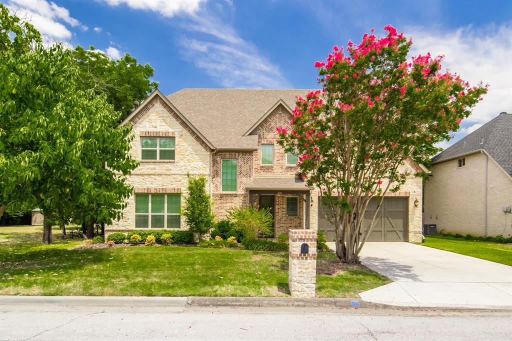 a front view of a house with a yard and a garage
