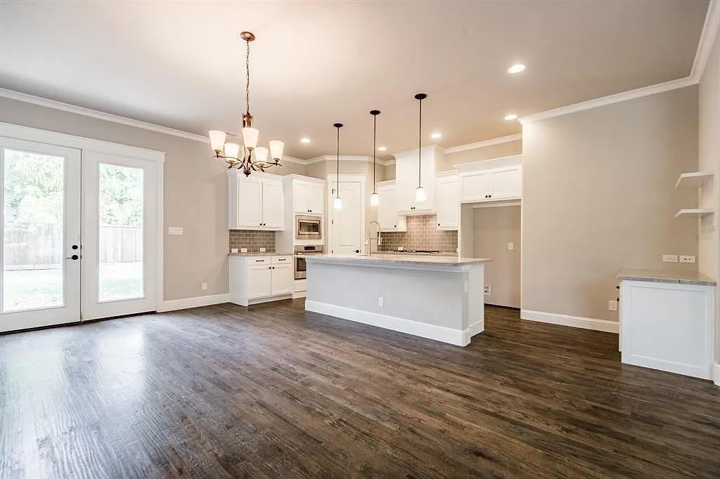 336 Kaye Street Coppell, TX 75019 - Photo 7 of 26 a large white kitchen with kitchen island white cabinets and wooden floor