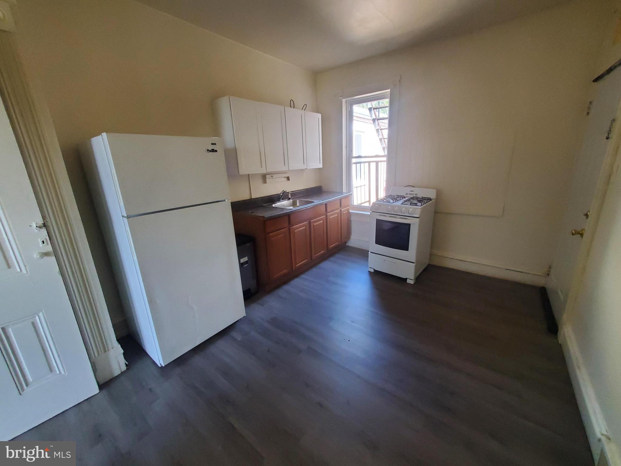 645 North 3rd Street, Unit 3 Reading, PA 19601 - Photo 2 of 10 a kitchen with a refrigerator a sink a stove a microwave and wooden floor