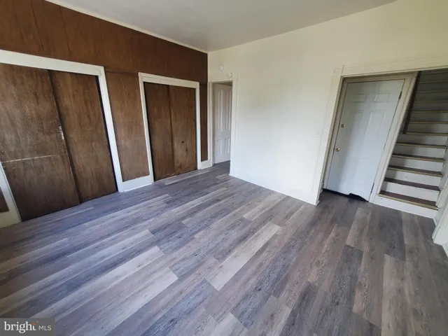 a view of a hallway with wooden floor and entryway