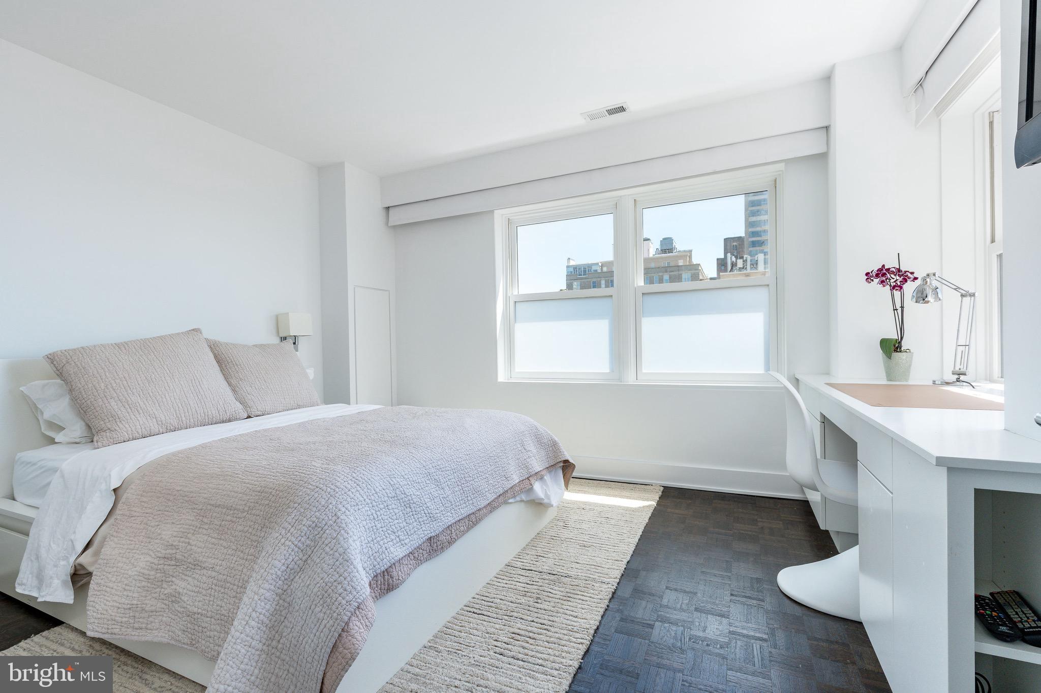 1830 Rittenhouse Square, Unit 17B Philadelphia, PA 19103 - Photo 31 of 39 a bedroom with a bed and a large window