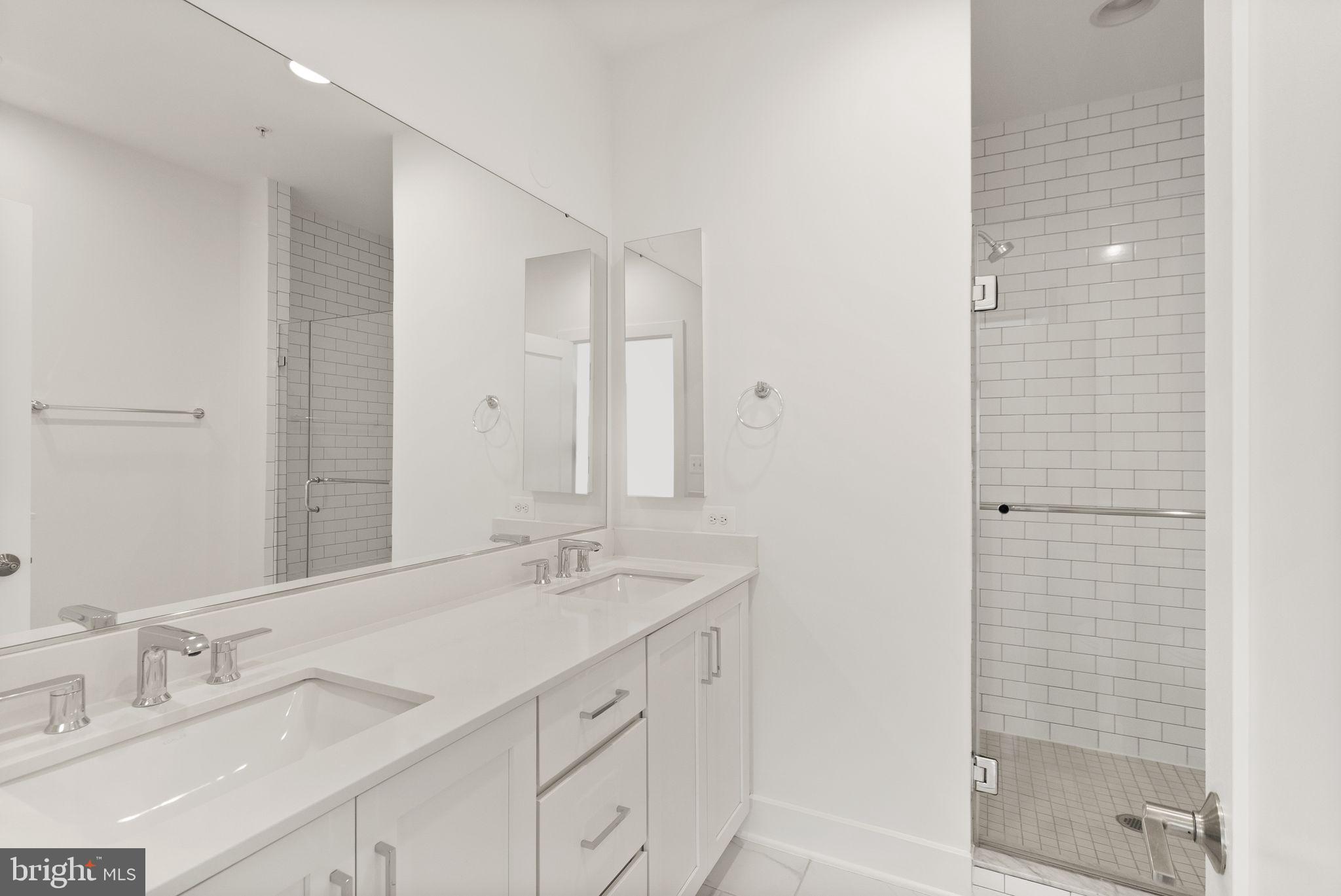 1862 Michael Faraday Drive Reston, VA 20190 - Photo 13 of 35 a bathroom with a double vanity sink mirror and shower