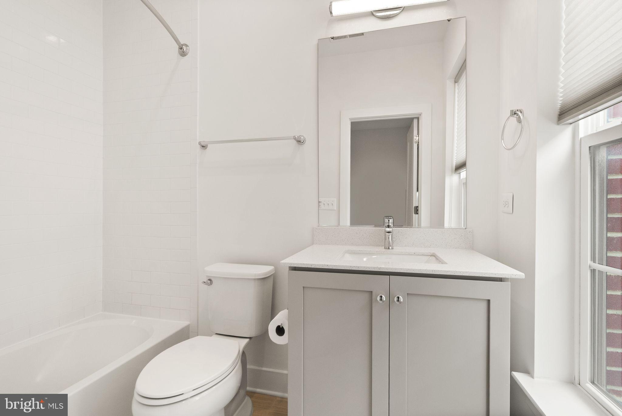 1862 Michael Faraday Drive Reston, VA 20190 - Photo 18 of 35 a bathroom with a granite countertop sink toilet a mirror and shower