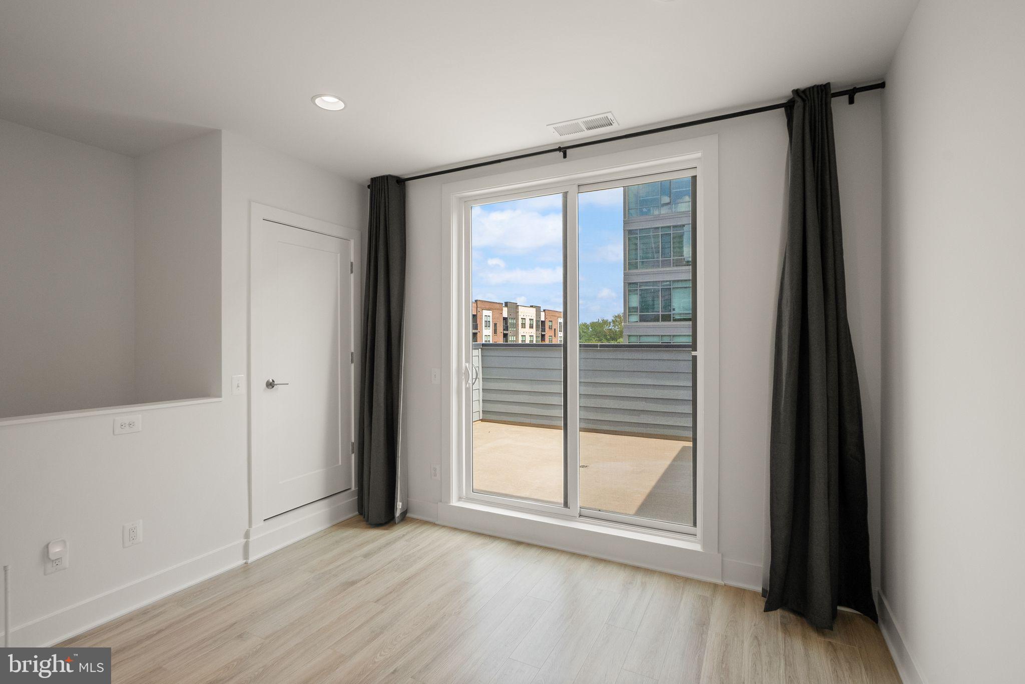 1862 Michael Faraday Drive Reston, VA 20190 - Photo 21 of 35 an empty room with wooden floor and windows
