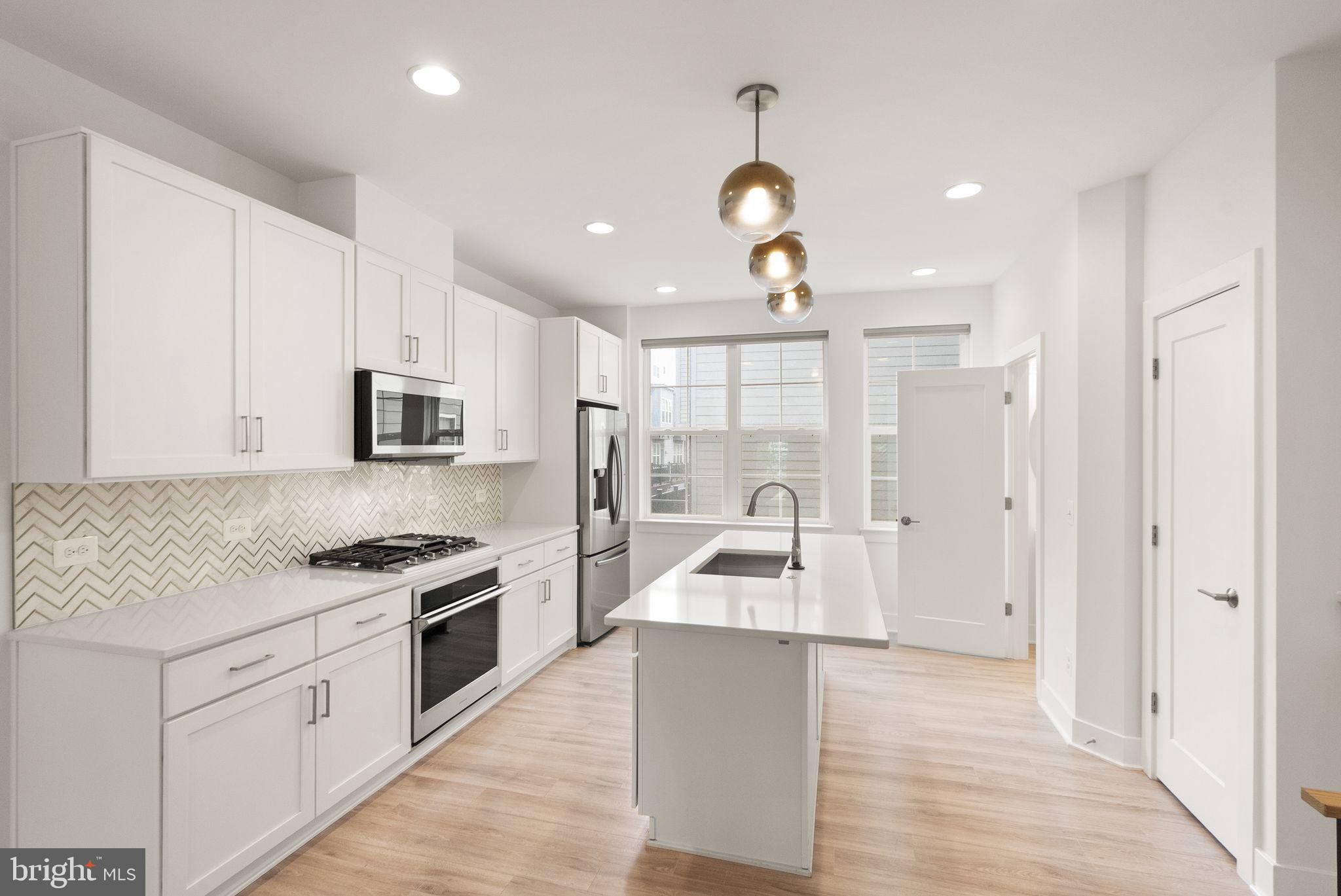 1862 Michael Faraday Drive Reston, VA 20190 - Photo 3 of 35 a large kitchen with stainless steel appliances granite countertop a stove and a sink with granite countertops