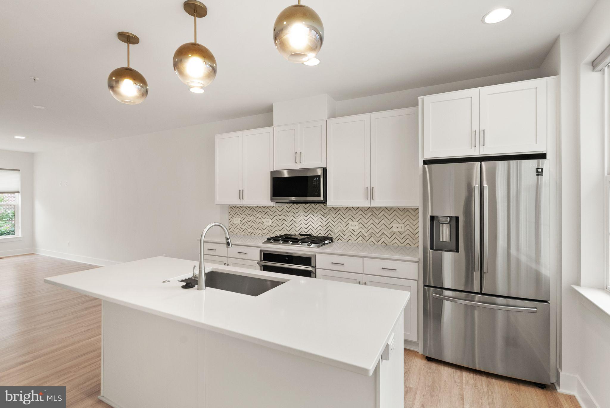 1862 Michael Faraday Drive Reston, VA 20190 - Photo 4 of 35 a kitchen with stainless steel appliances granite countertop a refrigerator a sink a stove and white cabinets