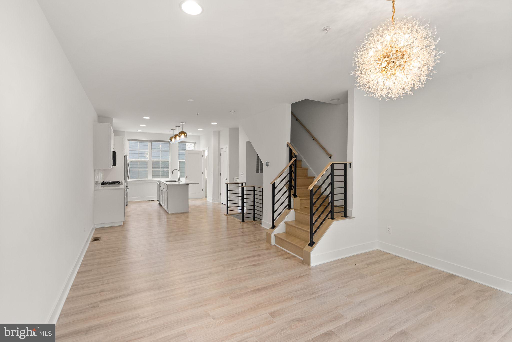 1862 Michael Faraday Drive Reston, VA 20190 - Photo 8 of 35 a view of a hallway with wooden floor and a chandelier