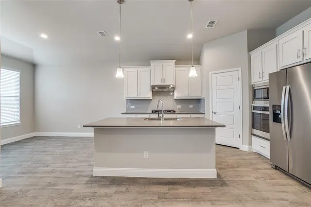 a view of kitchen with refrigerator stove and a ceiling fan