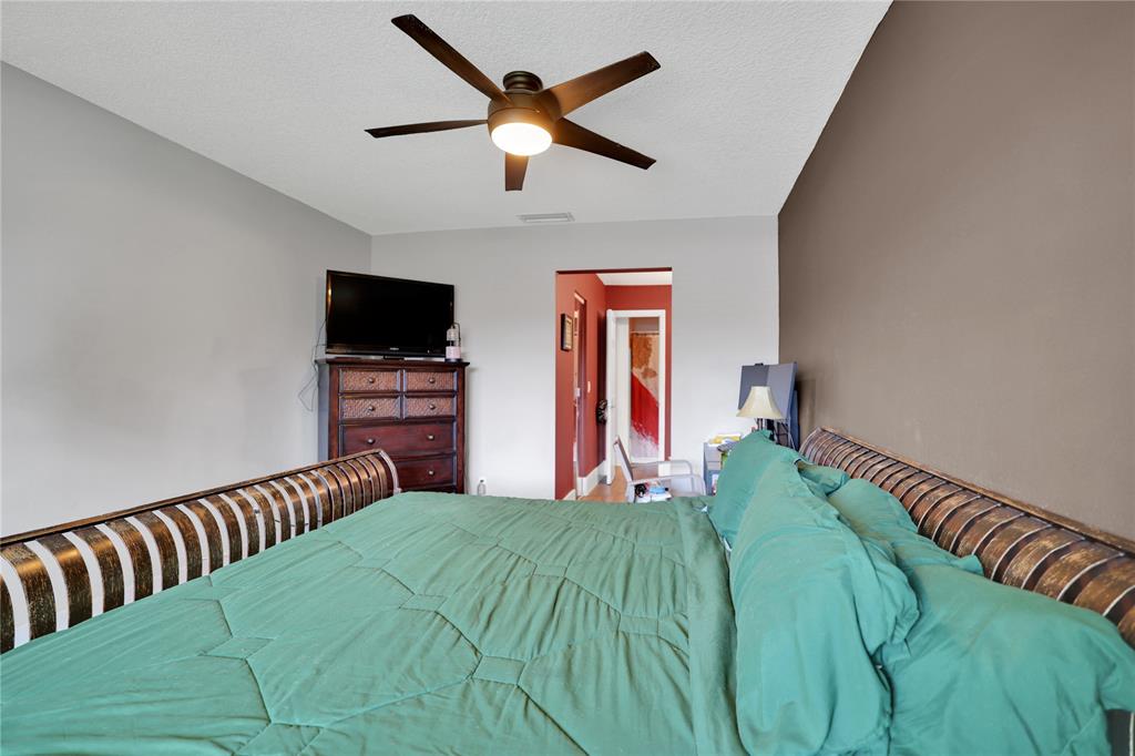 10700 Northwest 30th Place, Unit 7 Sunrise, FL 33322 - Photo 12 of 21 a bed room with a bed and a television