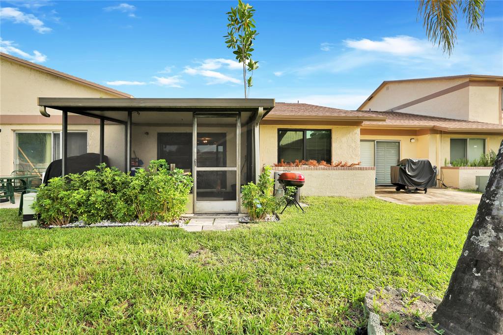 10700 Northwest 30th Place, Unit 7 Sunrise, FL 33322 - Photo 18 of 21 a front view of a house with garden