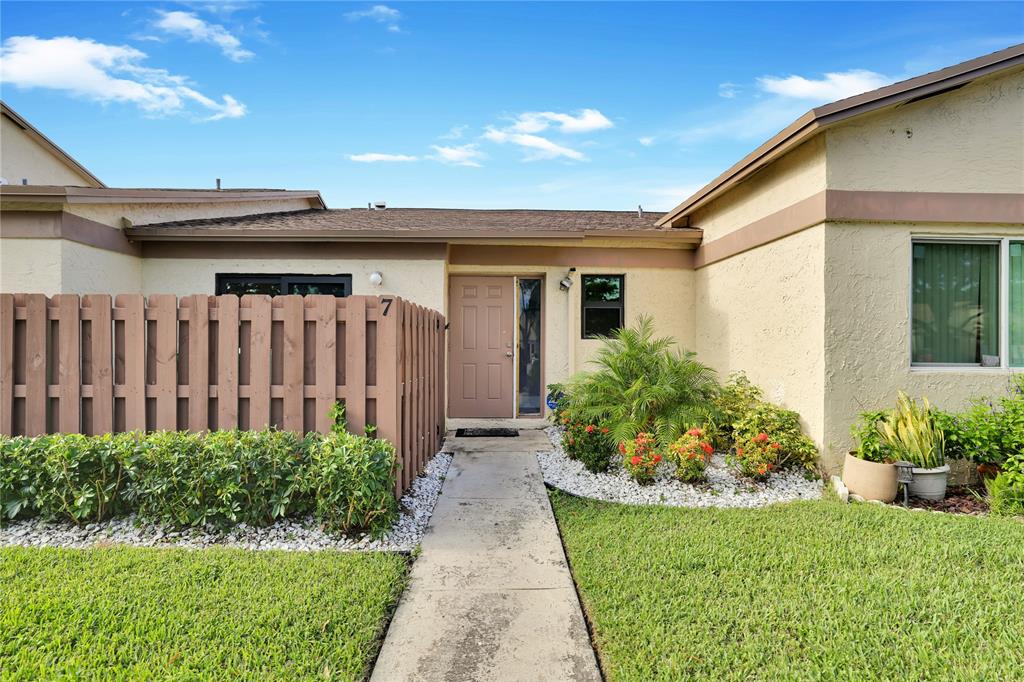 10700 Northwest 30th Place, Unit 7 Sunrise, FL 33322 - Photo 2 of 21 a front view of a house with garden