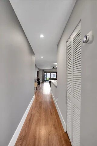 a view of a hallway with wooden floor and a potted plant