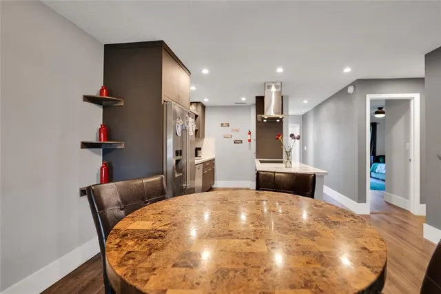 a kitchen with stainless steel appliances kitchen island granite countertop a sink and a refrigerator