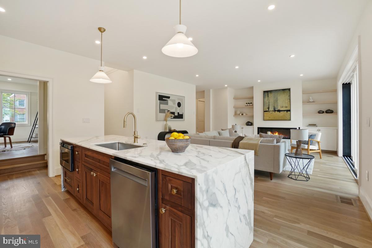 4339 Windom Place Northwest Washington, DC 20016 - Photo 16 of 45 a kitchen with stainless steel appliances granite countertop sink stove and wooden floor