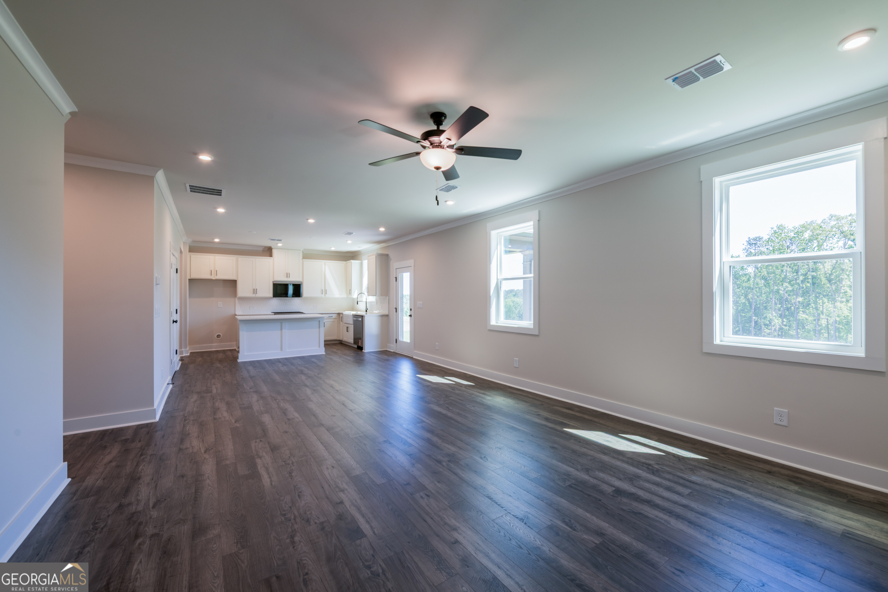 152 Henley Street, Unit 13 Canton, GA 30114 - Photo 5 of 37 a view of a big room with wooden floor a ceiling fan and windows