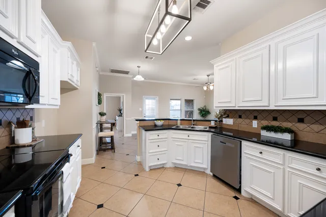 a kitchen with stainless steel appliances granite countertop a sink and cabinets