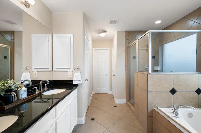 a bathroom with a granite countertop sink and a bathtub