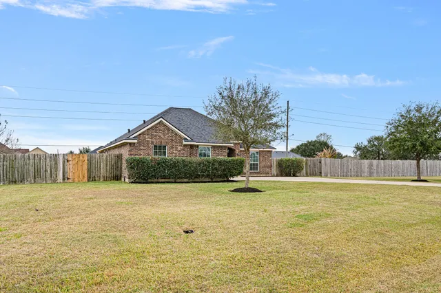 a front view of house with yard and trees in the background