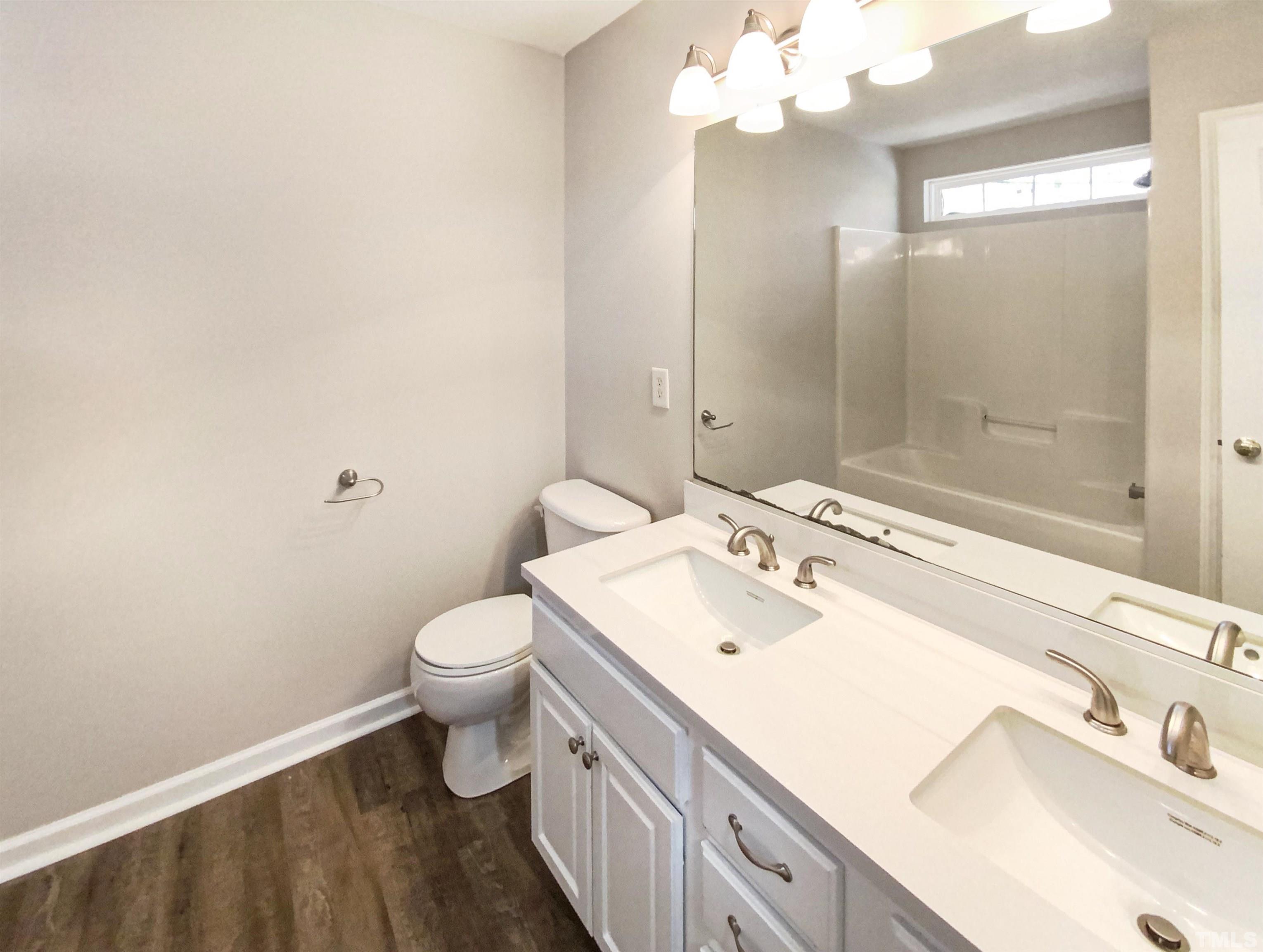 203 Caley Road Apex, NC 27502 - Photo 15 of 19 a bathroom with a sink a toilet and shower