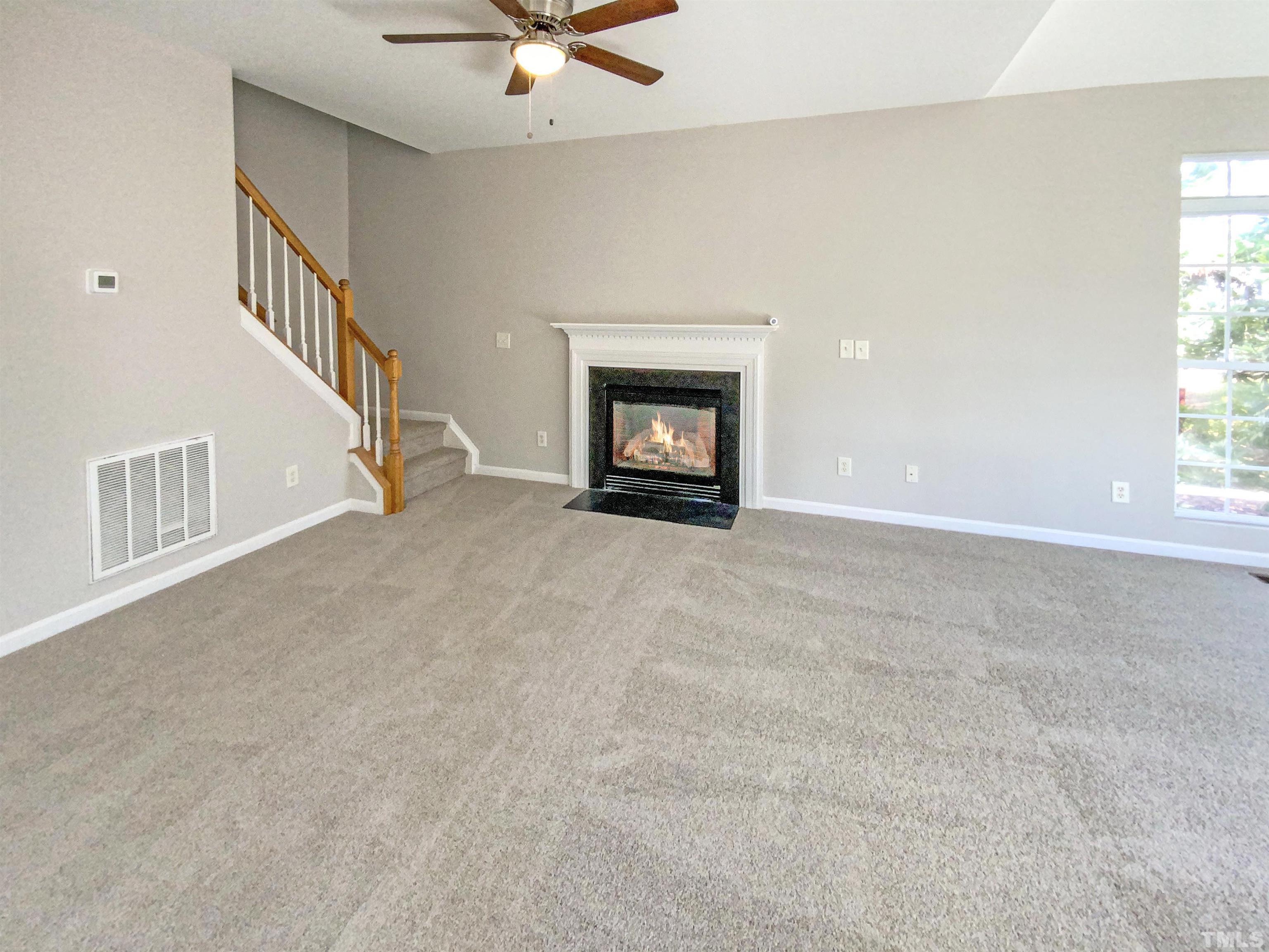 203 Caley Road Apex, NC 27502 - Photo 3 of 19 a view of an empty room with a window and fireplace