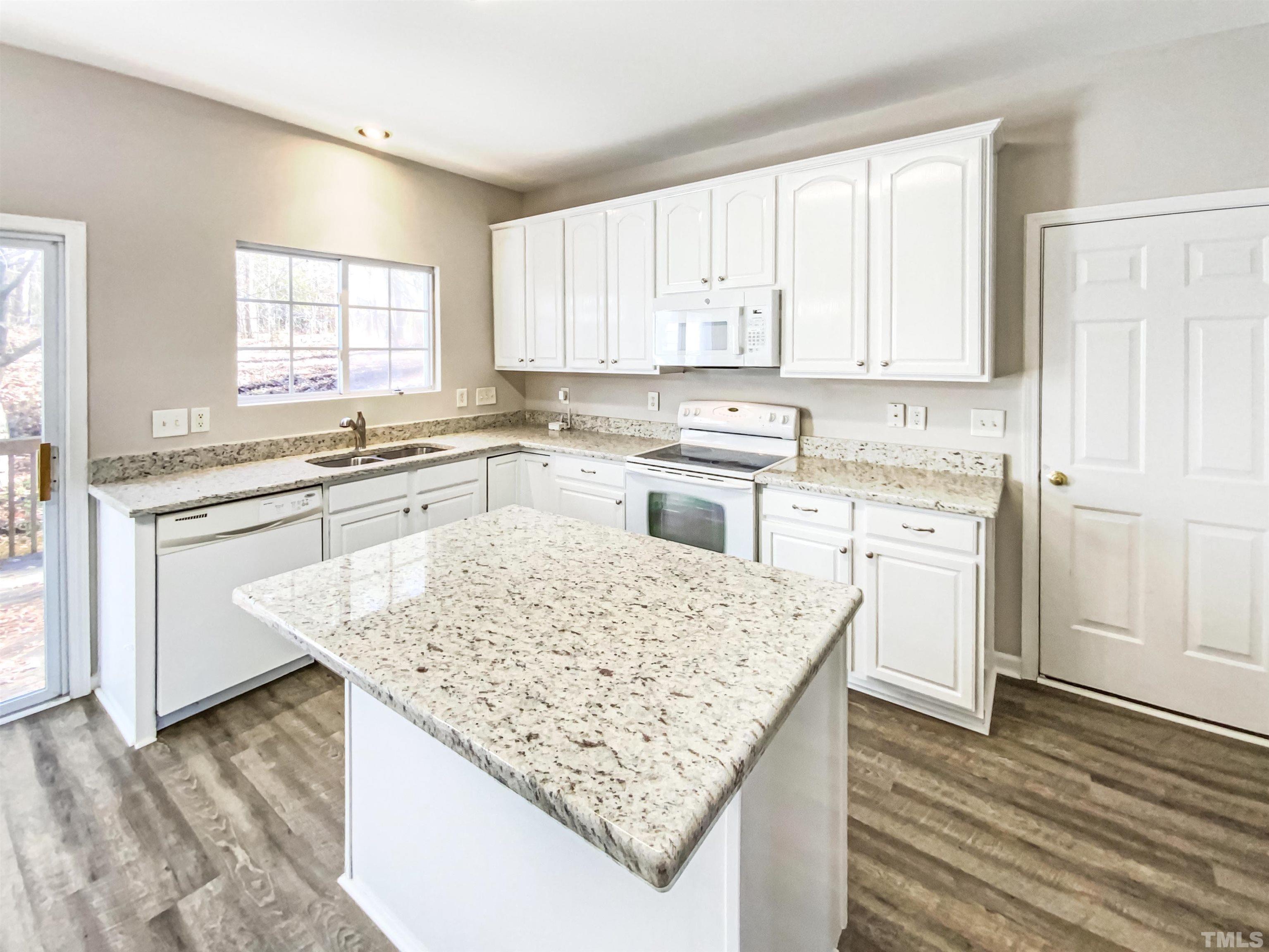 203 Caley Road Apex, NC 27502 - Photo 7 of 19 a kitchen with stainless steel appliances granite countertop a table chairs sink and cabinets
