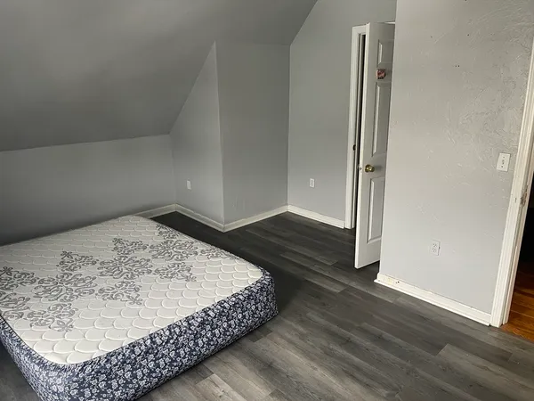 a view of a bedroom with wooden floor and hallway