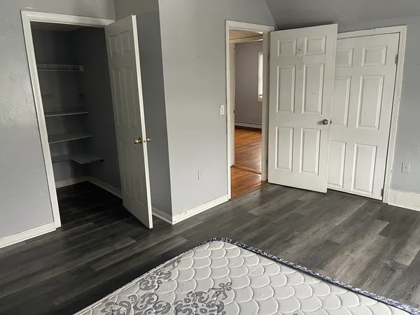 a view of a hallway with wooden floor and closet
