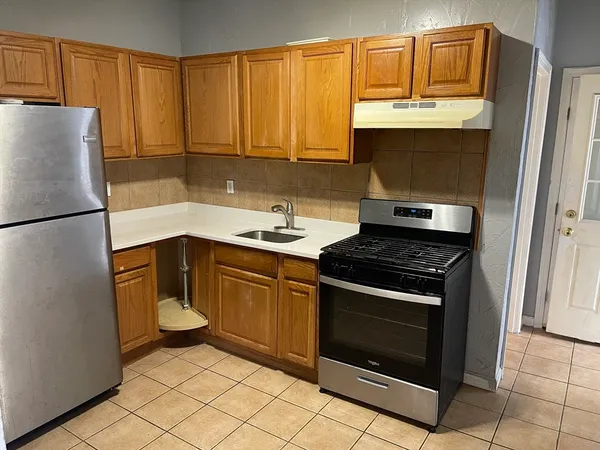 a kitchen with a refrigerator stove and cabinets
