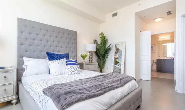 a bedroom with a bed and a potted plant