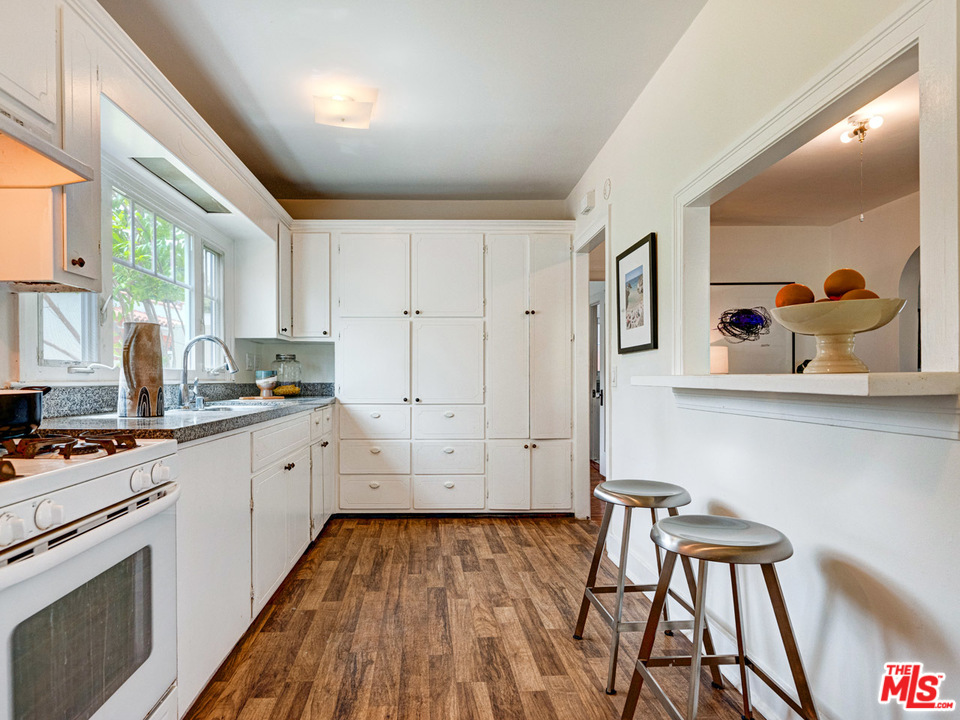 241 Ruth Avenue Venice, CA 90291 - Photo 18 of 25 a kitchen with wooden floor and white cabinets