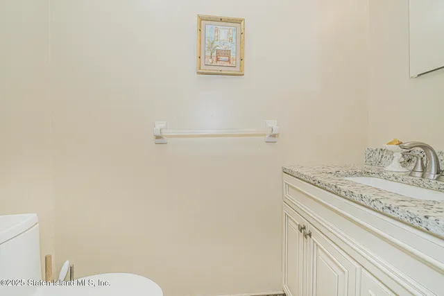a bathroom with a granite countertop sink toilet and vanity