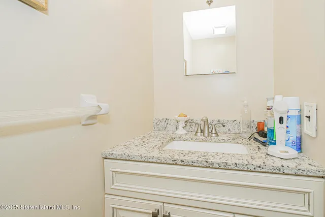 a bathroom with a granite countertop sink and a mirror