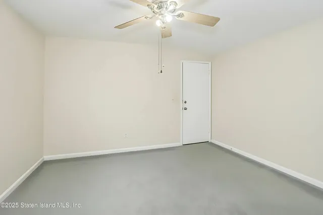 an empty room with a ceiling fan and a window