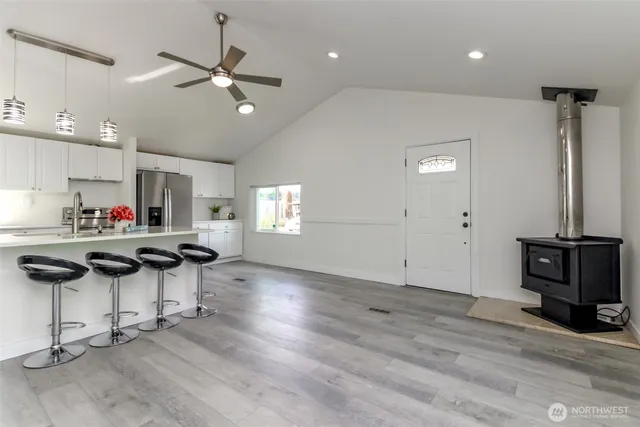 a kitchen with stainless steel appliances kitchen island granite countertop a stove and a wooden floors