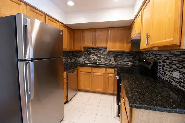 a kitchen with granite countertop a refrigerator and a sink
