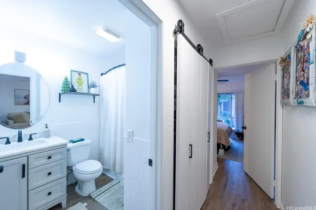 a bathroom with a granite countertop toilet sink and mirror
